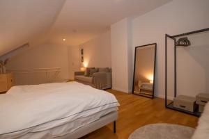 - une chambre avec un lit blanc et un miroir dans l'établissement Im Zentrum schöner Wohnen inkl. Parkplatz, à Paderborn