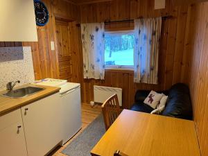 eine Küche mit einem Tisch, einem Sofa und einem Tisch in der Unterkunft Apartment Grønlid in Rauland