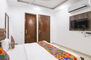 um quarto com uma cama e uma televisão e uma cama sidx sidx em FabExpress The Premium Villa em Nova Deli