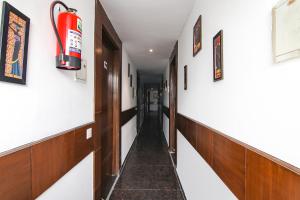 um corredor com um extintor de incêndio na parede em FabExpress The Premium Villa em Nova Deli