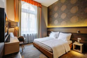 um quarto de hotel com uma cama e uma janela em Hotel Museum Budapest em Budapeste
