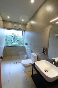 a bathroom with a toilet and a sink and a shower at Petals Resorts Wayanad in Tariyod