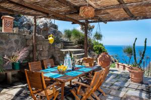 a table and chairs on a patio with a view of the ocean at Villa Giò Punta Caruso in Ischia