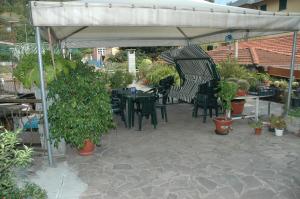 eine Terrasse mit einem Tisch und Stühlen unter einem Baldachin in der Unterkunft Hotel Valentino in Perosa Argentina