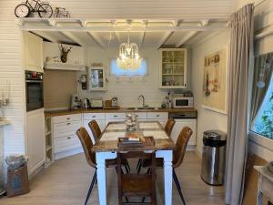 een keuken met een tafel en stoelen en een kroonluchter bij Chalet Sint Barbara in Zutendaal