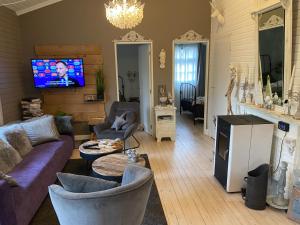 - un salon avec un canapé, des chaises et une télévision dans l'établissement Chalet Sint Barbara, à Zutendaal