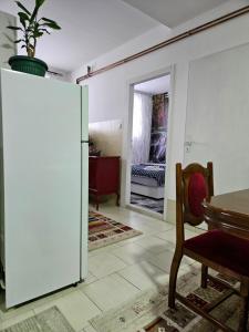 uma sala de estar com um frigorífico branco e uma mesa em Apartman Juga em Kremna
