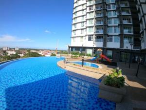 a large swimming pool in front of a large building at Moonstone studio D'Perdana Apartment in Kota Bharu