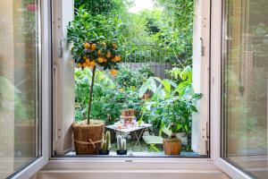 uma janela aberta com uma mesa num jardim em My Nest Inn Paris Quartier Latin - 27m2 - Rénové em Paris