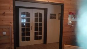 drzwi w pokoju z drewnianymi ścianami w obiekcie boddenbackpacker w mieście Bartelshagen