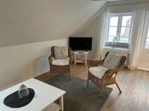 een woonkamer met 2 stoelen en een televisie bij Kegelrobbe in Wyk auf Föhr
