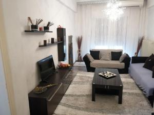 sala de estar con sofá y TV en Evangelle's Apartment, en Tríkala