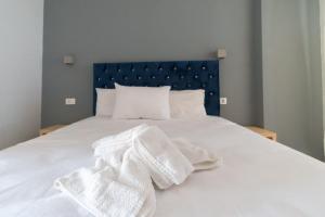 Una cama con toallas blancas encima. en N. Ammos Lichnos en Párga