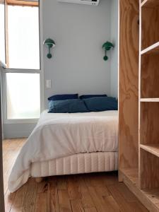 - une chambre avec un grand lit blanc et des oreillers bleus dans l'établissement Ocean Lodge_plage Bourdaines, à Seignosse