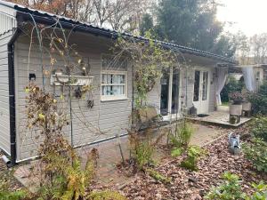 una pequeña casa con una valla delante de ella en Chalet Sint Barbara, en Zutendaal