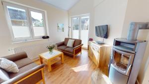 a living room with a fireplace and a couch and a tv at Feriendorf Südstrand Haus 22 in Pelzerhaken