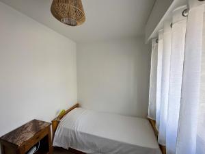 a small bedroom with a bed and a window at BRUNEEL - Appartement 4 personnes Carnac in Carnac
