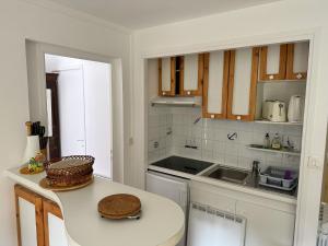 a white kitchen with a table and a sink at BRUNEEL - Appartement 4 personnes Carnac in Carnac