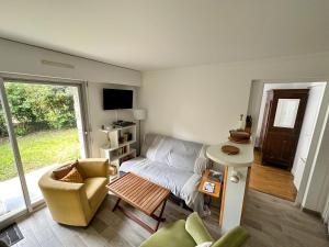 a living room with a couch and a table at BRUNEEL - Appartement 4 personnes Carnac in Carnac
