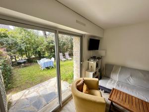 a living room with a sliding glass door to a patio at BRUNEEL - Appartement 4 personnes Carnac in Carnac
