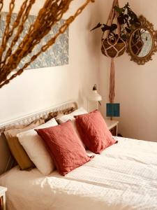 1 dormitorio con 1 cama con almohadas rojas y blancas en Cuarto Botánico Stylish Studio with Shared Pool, en Tiagua