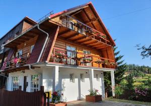 a wooden house with balconies and flowers on it at Dom na Karkonoskiej in Karpacz