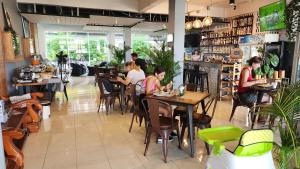 un grupo de personas sentadas en mesas en un restaurante en iRest Ao Nang en Ao Nang Beach