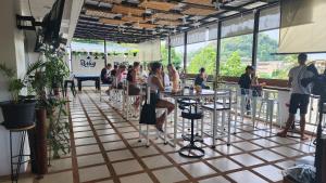 um grupo de pessoas sentadas em mesas em um restaurante em iRest Ao Nang em Praia de Ao Nang