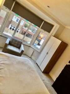 a bedroom with a bed and a large window at Two the Manor Born 3 bedroom house in Tynemouth