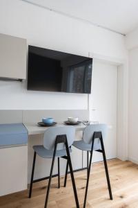 a kitchen with a table with two chairs and a tv at Casa Kaleido in Trento