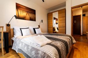 1 dormitorio con 1 cama grande con almohadas blancas en MAESTRIA POLANICA, en Polanica-Zdrój