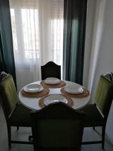 een eettafel met 2 stoelen en borden erop bij Coccinella in Montesilvano