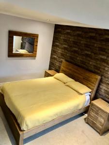 ein Schlafzimmer mit einem großen Bett mit Ziegelwand in der Unterkunft Two the Manor Born 3 bedroom house in Tynemouth