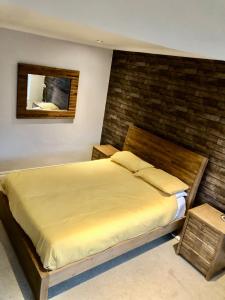 1 dormitorio con 1 cama grande y pared de ladrillo en Two the Manor Born 3 bedroom house, en Tynemouth