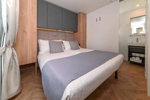 1 Schlafzimmer mit einem großen Bett und einem Badezimmer in der Unterkunft MORENIA Park Villas in Podaca