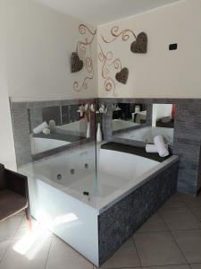 a bathroom with a tub with hearts on the wall at Green Hotel Ninfa in Avigliana
