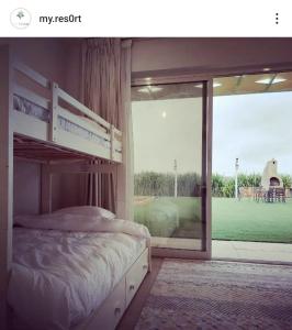 a bedroom with a bunk bed and a large window at My Resort in Al Rahba