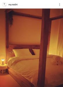 a bedroom with a large bed with a wooden frame at My Resort in Al Rahba