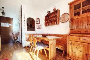 uma sala de jantar com uma mesa de madeira e cadeiras em - La Casetta di Legno - i colori della natura em Foppolo