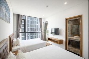 岘港Hai Trieu Hotel的有两张床和一台电视的酒店房间