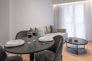 - un salon avec une table et deux verres de vin dans l'établissement Kriel Suites by LIV Homes, à Athènes