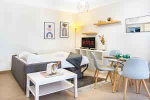 een woonkamer met een bank en een tafel bij Vue Monaco & Tour Odéon, Terrasse, Parking Gratuit in Beausoleil