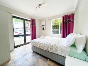 a bedroom with a bed with purple curtains at Wylie 5 Bedrooms house in Rotorua