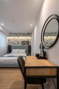 Kriel Suites by LIV Homes في أثينا: غرفة نوم بسرير ومرآة وطاولة