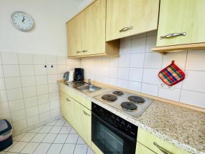 a kitchen with a stove and a sink at Haus Louise/Sternenblick in Warnemünde