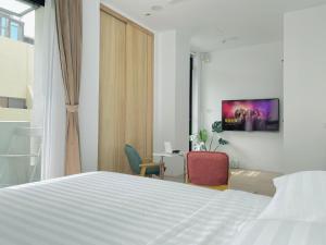 1 dormitorio con cama, escritorio y silla en 珍遇珍寓電梯民宿 June June House, en Tainan