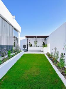 an empty backyard with a green lawn at كرم شاليه in Barka