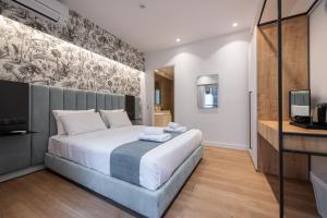 um quarto com uma cama grande e uma televisão em Kriel Suites by LIV Homes em Atenas