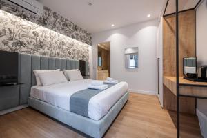 una camera con un grande letto e una televisione di Kriel Suites by LIV Homes ad Atene