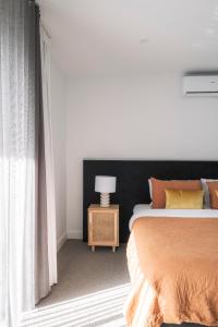 a bedroom with a bed and a table with a lamp at Downtown House in Geelong